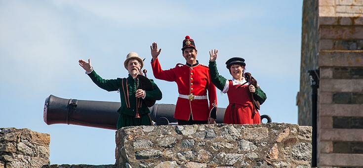 People in historical costumes by a cannon